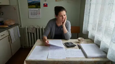 Osoba pozerá na rozpočet a zmluvu o nájme alebo hypotéke na stole